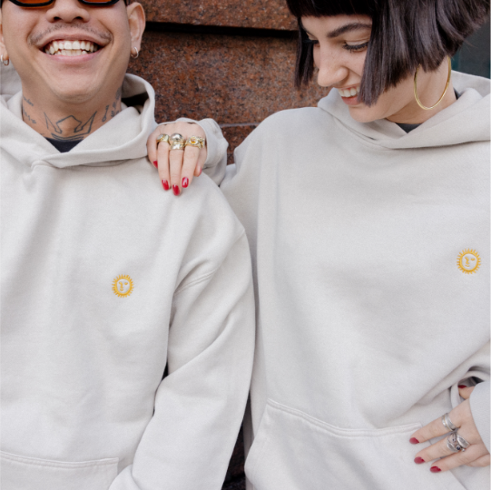 Two people wearing matching light gray hoodies with a Federal logo on the chest, sitting close together.